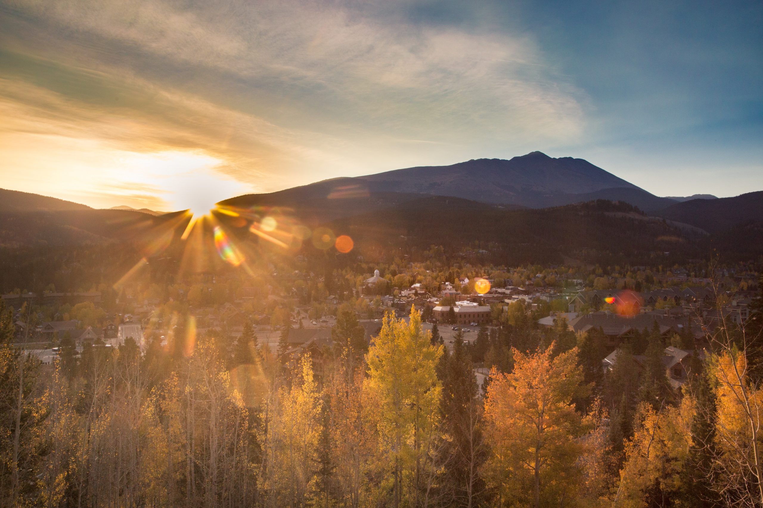 Sunrise over Breckenridge with yellow trees in the foreground.