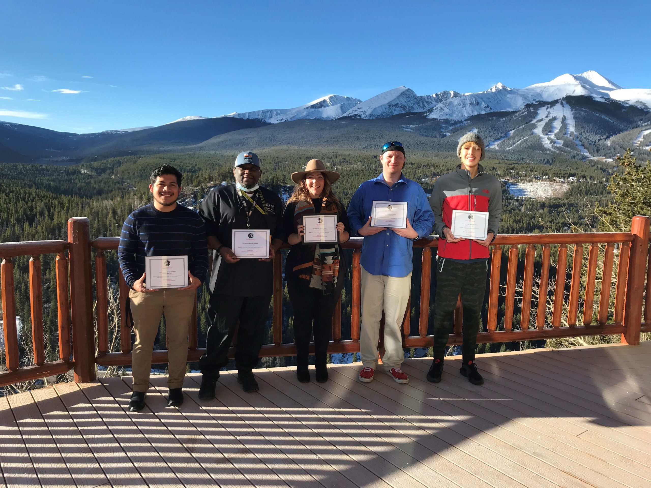 group standing in front of mountains being honored as guest service champions